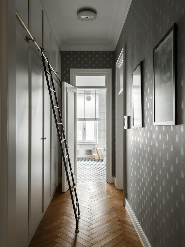 Idee per un ingresso o corridoio chic con pareti grigie, pavimento in legno massello medio e pavimento marrone
