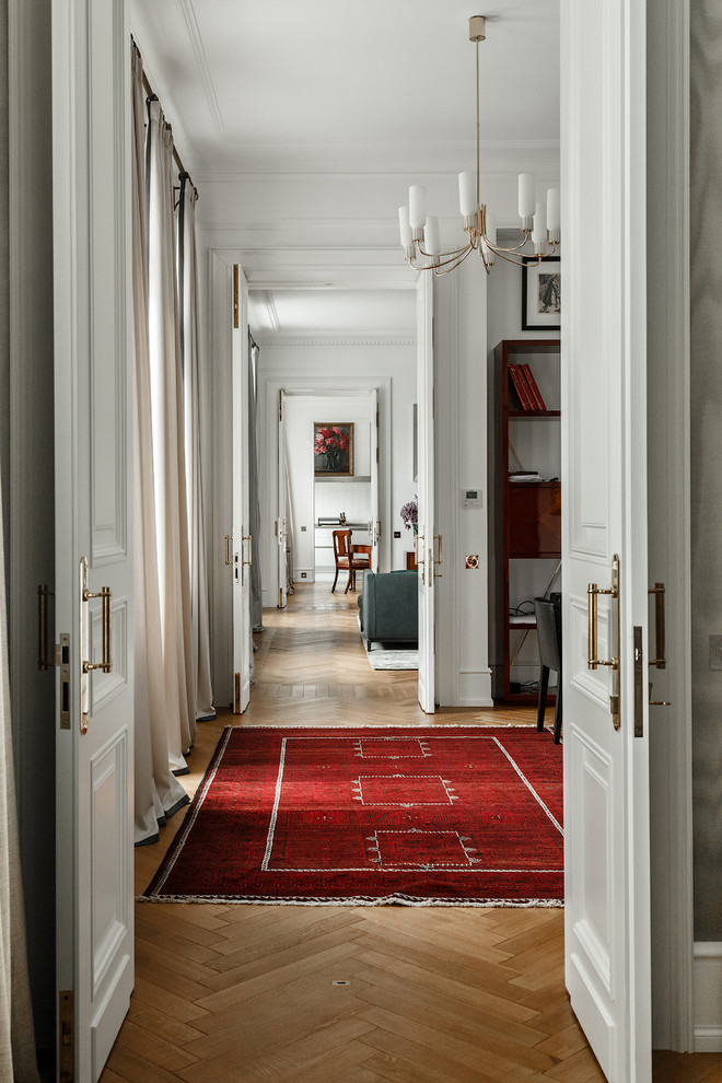 Стильный дизайн: коридор в стиле неоклассика (современная классика) с белыми стенами и светлым паркетным полом - последний тренд