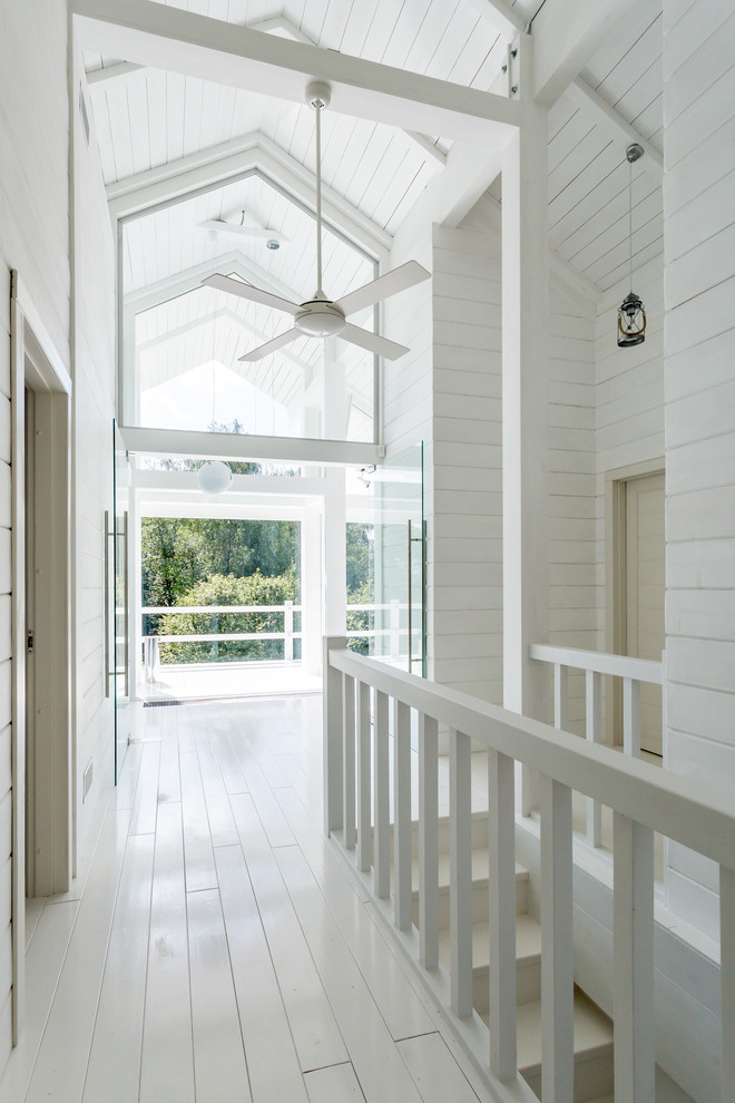 Пример оригинального дизайна: коридор в скандинавском стиле с белыми стенами и деревянным полом