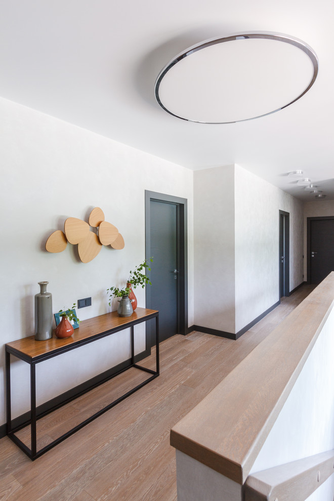 Идея дизайна: коридор среднего размера в современном стиле с серыми стенами, деревянным полом и бежевым полом