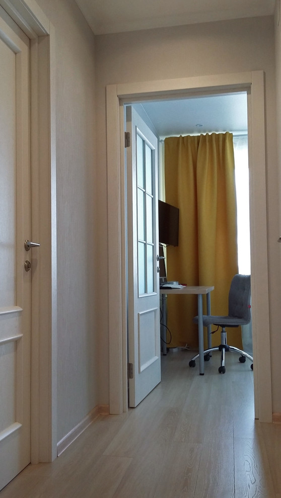 Cette image montre un petit couloir design avec un mur gris, sol en stratifié et un sol beige.