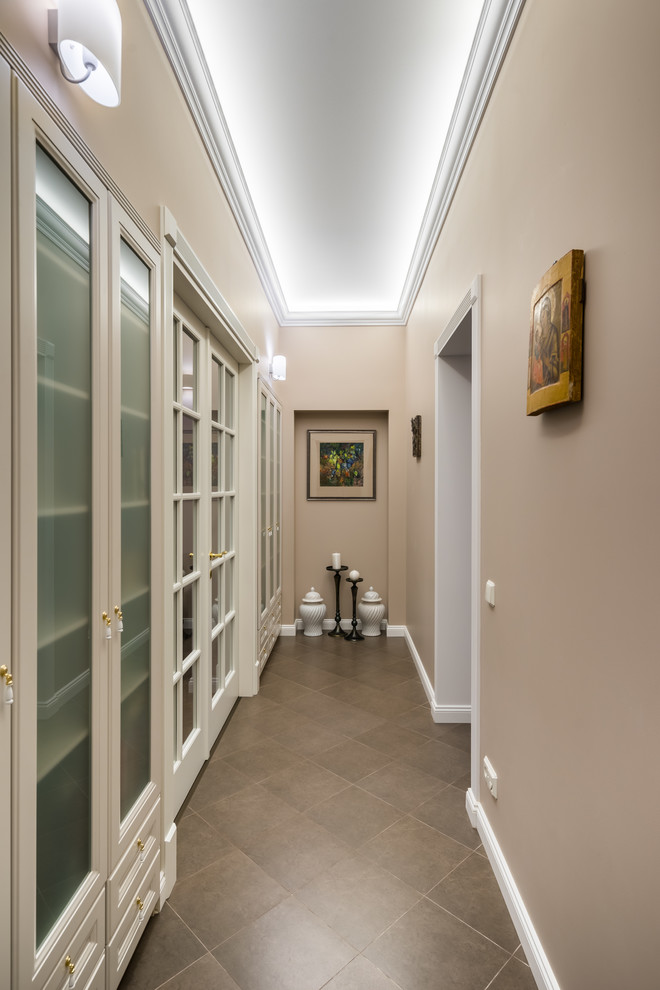 На фото: коридор в стиле неоклассика (современная классика) с бежевыми стенами и коричневым полом с
