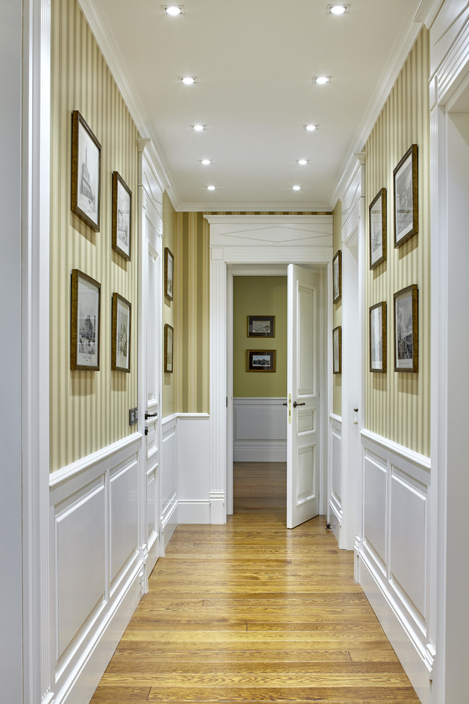 Idee per un ingresso o corridoio chic con pareti beige e pavimento in legno massello medio