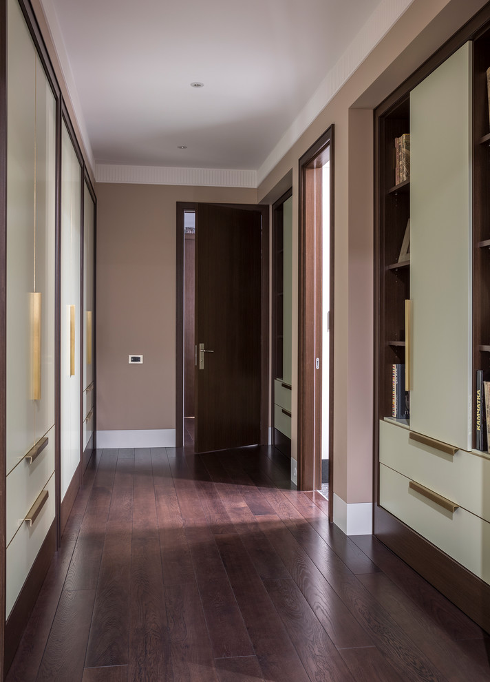 Exemple d'un couloir chic de taille moyenne avec un mur beige, parquet foncé et un sol marron.