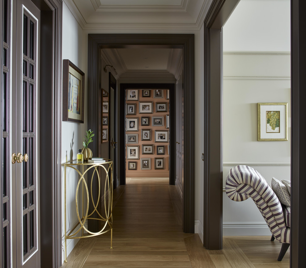 Свежая идея для дизайна: коридор среднего размера в стиле неоклассика (современная классика) с белыми стенами, паркетным полом среднего тона и коричневым полом - отличное фото интерьера