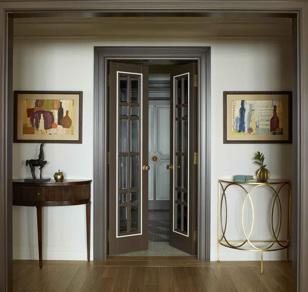 Ispirazione per un ingresso o corridoio classico di medie dimensioni con pareti bianche, pavimento in legno massello medio e pavimento marrone