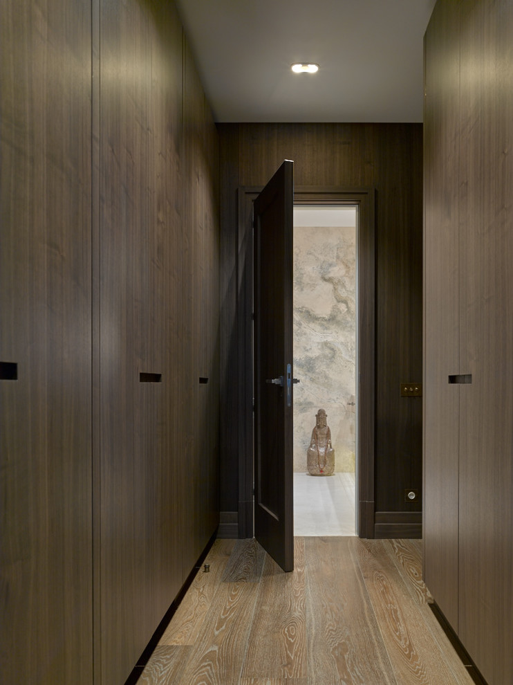 Cette image montre un couloir design avec un mur marron et un sol en bois brun.