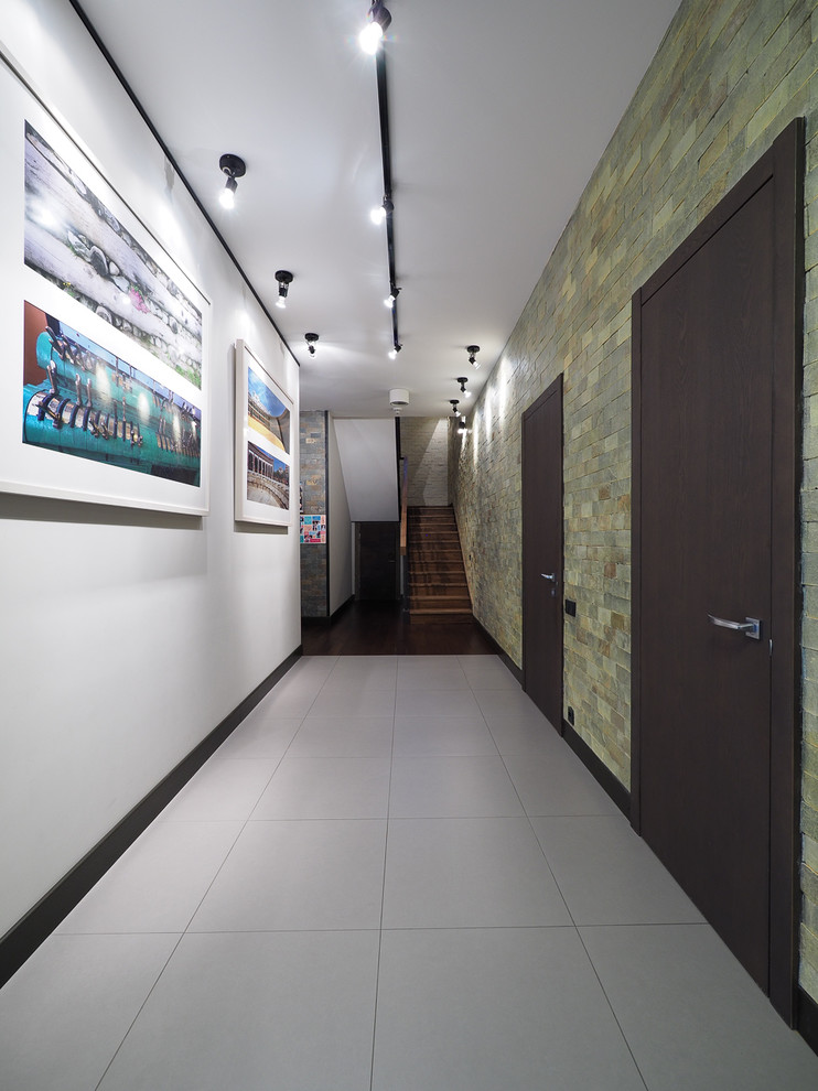 Réalisation d'un couloir design de taille moyenne avec un mur gris, un sol en carrelage de porcelaine et un sol gris.