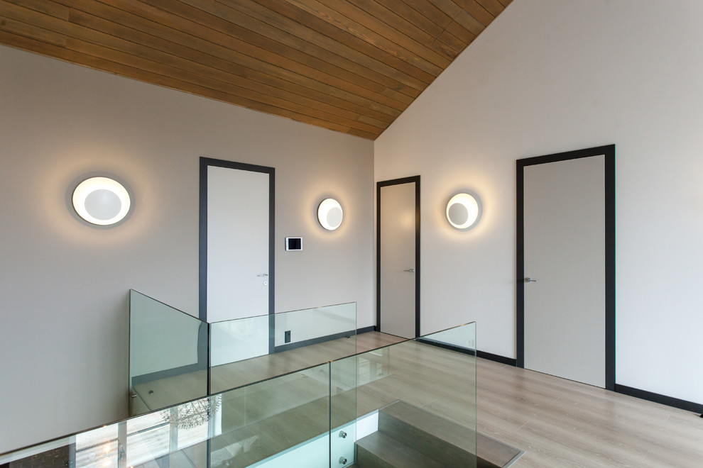 На фото: коридор в современном стиле с белыми стенами, полом из ламината и бежевым полом с