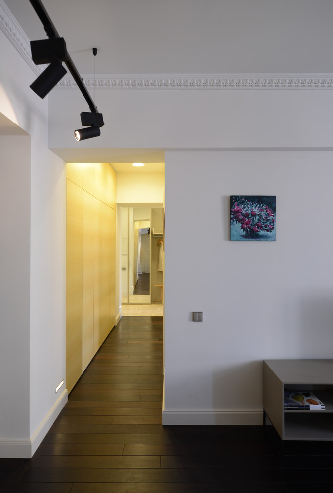 Стильный дизайн: коридор среднего размера в современном стиле с белыми стенами и темным паркетным полом - последний тренд