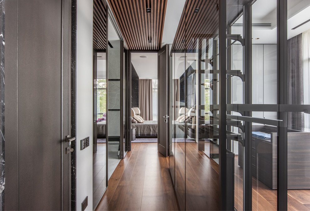 Esempio di un ingresso o corridoio design con pavimento in legno massello medio, pavimento marrone e pareti bianche