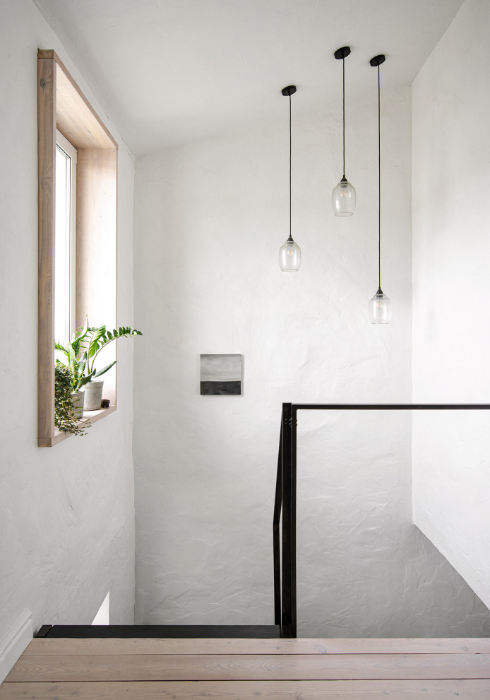 Inspiration för små minimalistiska hallar, med vita väggar, målat trägolv och vitt golv