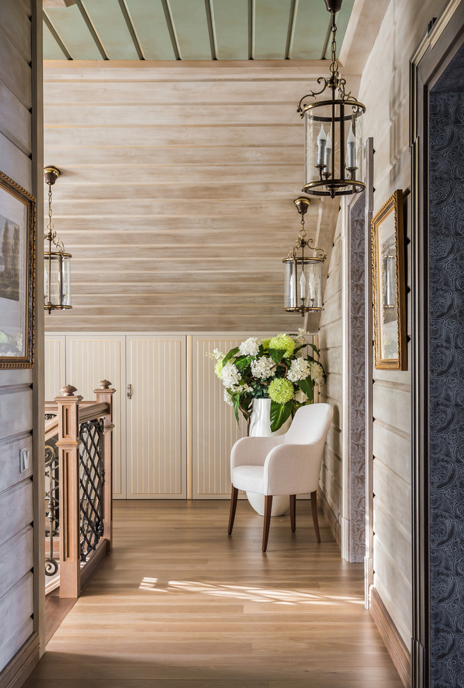 Diseño de recibidores y pasillos tradicionales de tamaño medio con paredes beige, suelo de madera clara y suelo beige