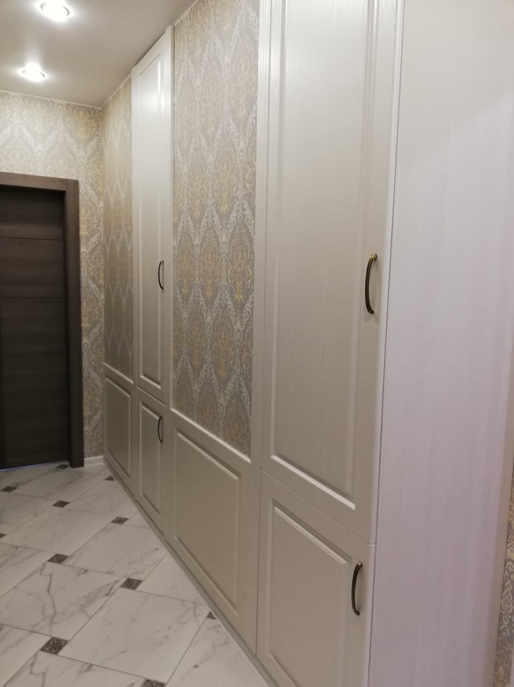 Exemple d'un petit couloir chic avec un mur beige, un sol en carrelage de céramique et un sol blanc.