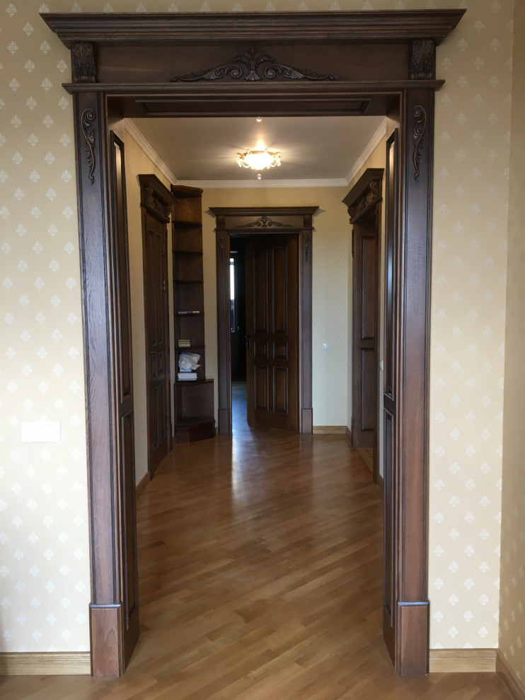 Esempio di un ingresso o corridoio tradizionale di medie dimensioni con pareti beige, pavimento in legno massello medio, pavimento beige e carta da parati