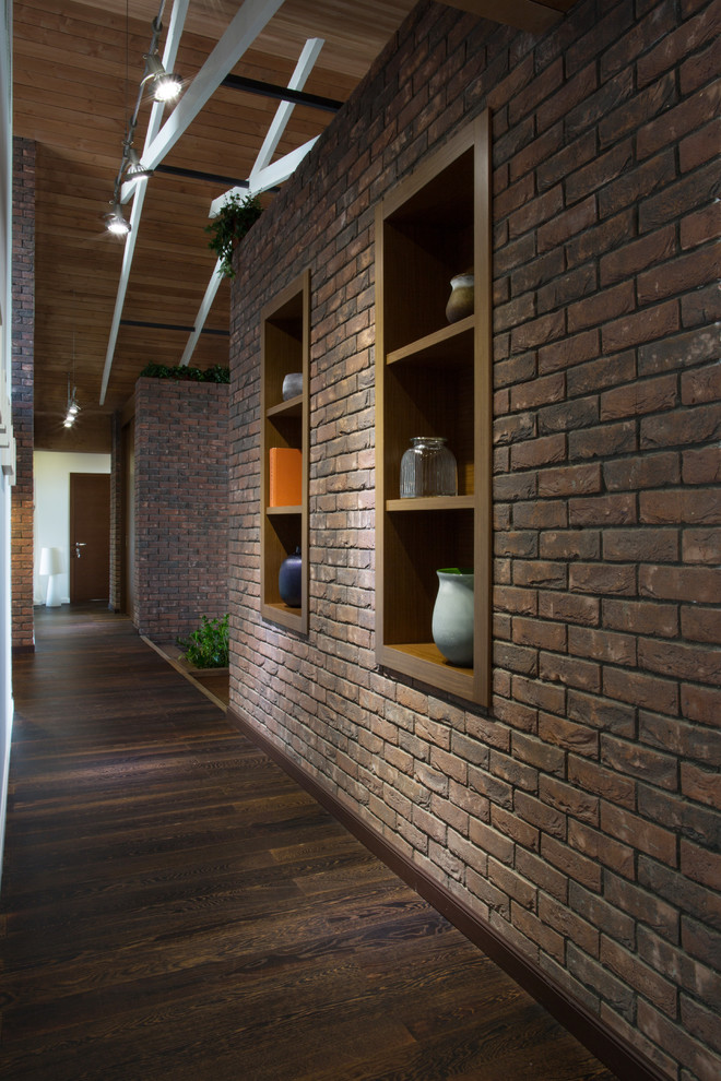 На фото: большой коридор в современном стиле с коричневыми стенами, полом из ламината и коричневым полом с