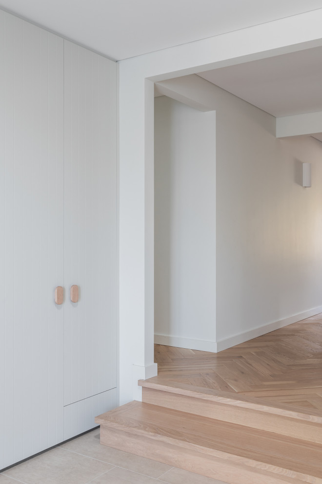 Imagen de recibidores y pasillos actuales con paredes blancas y suelo de madera clara