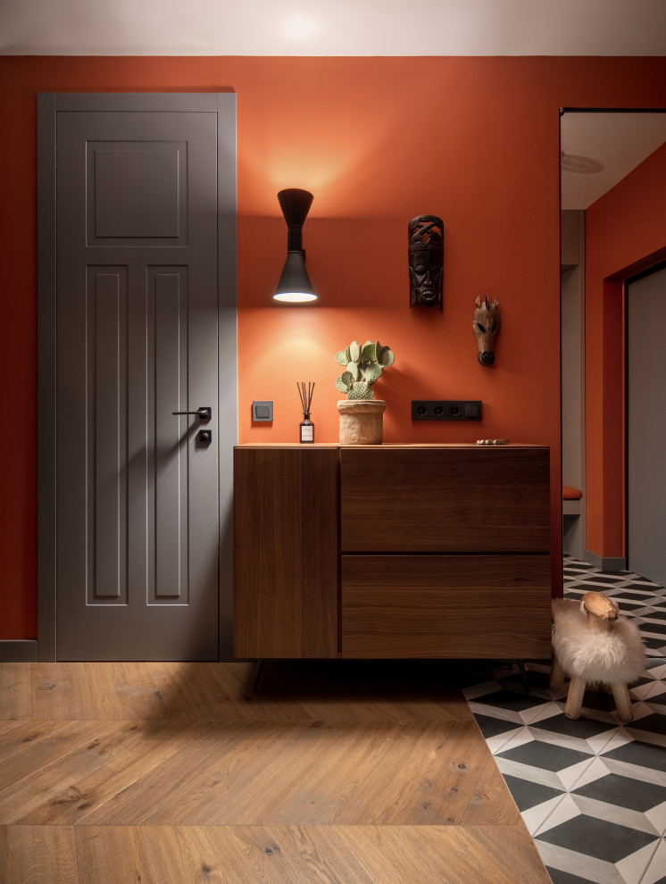 Großer Moderner Flur mit oranger Wandfarbe, braunem Holzboden und braunem Boden in Sonstige