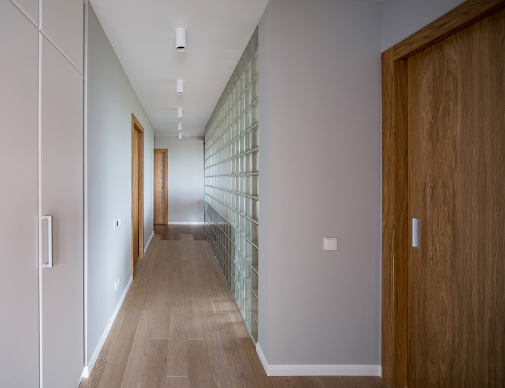 На фото: коридор среднего размера в современном стиле с полом из керамогранита и коричневым полом с