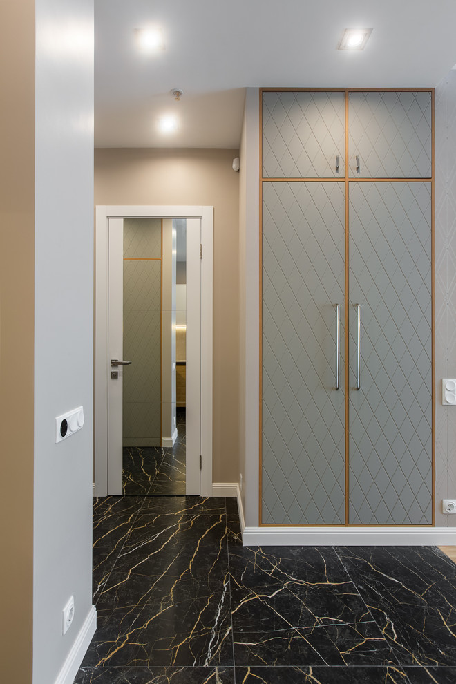 Idée de décoration pour un couloir design de taille moyenne avec un mur beige, un sol en carrelage de porcelaine et un sol noir.