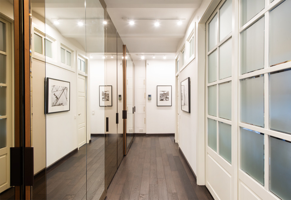 Cette image montre un couloir design de taille moyenne avec un mur blanc, parquet foncé et un sol noir.