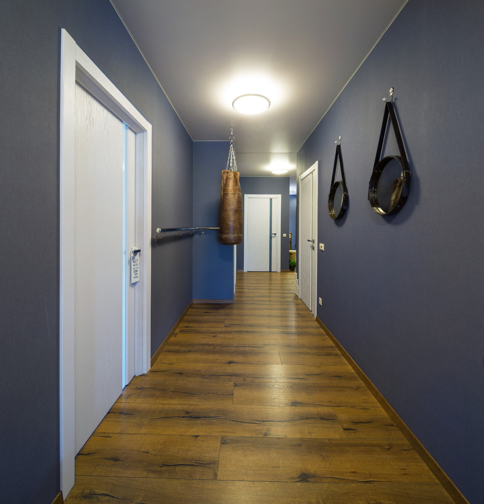 Пример оригинального дизайна: коридор в современном стиле с синими стенами, паркетным полом среднего тона и коричневым полом