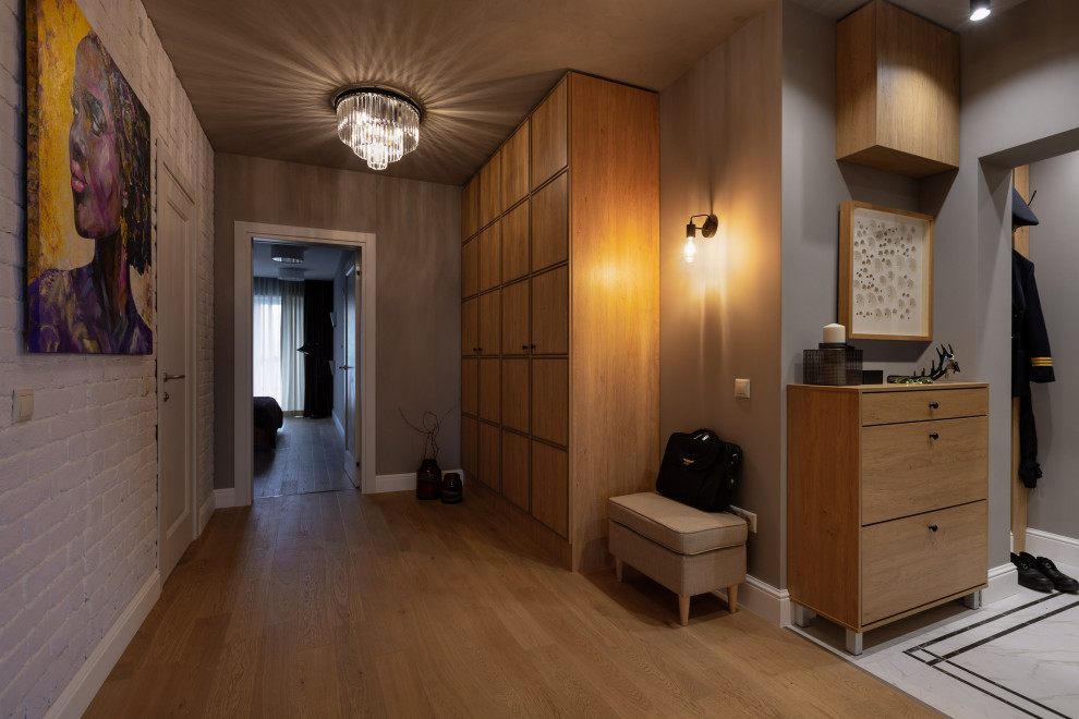 Diseño de recibidores y pasillos actuales con paredes grises, suelo marrón y suelo de madera en tonos medios