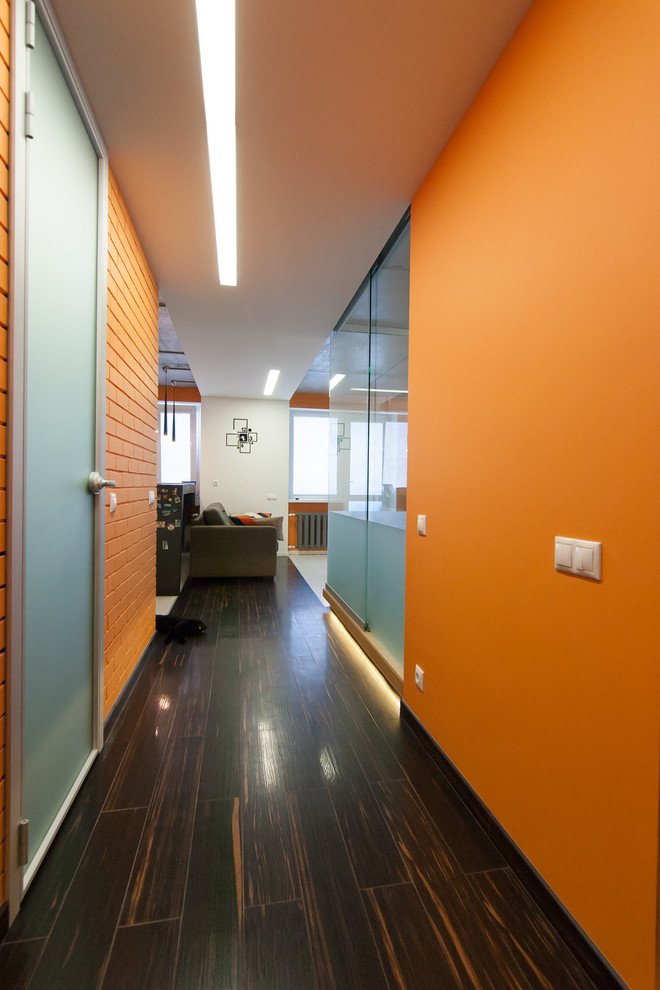 Cette photo montre un couloir tendance avec un mur orange et un sol en carrelage de porcelaine.