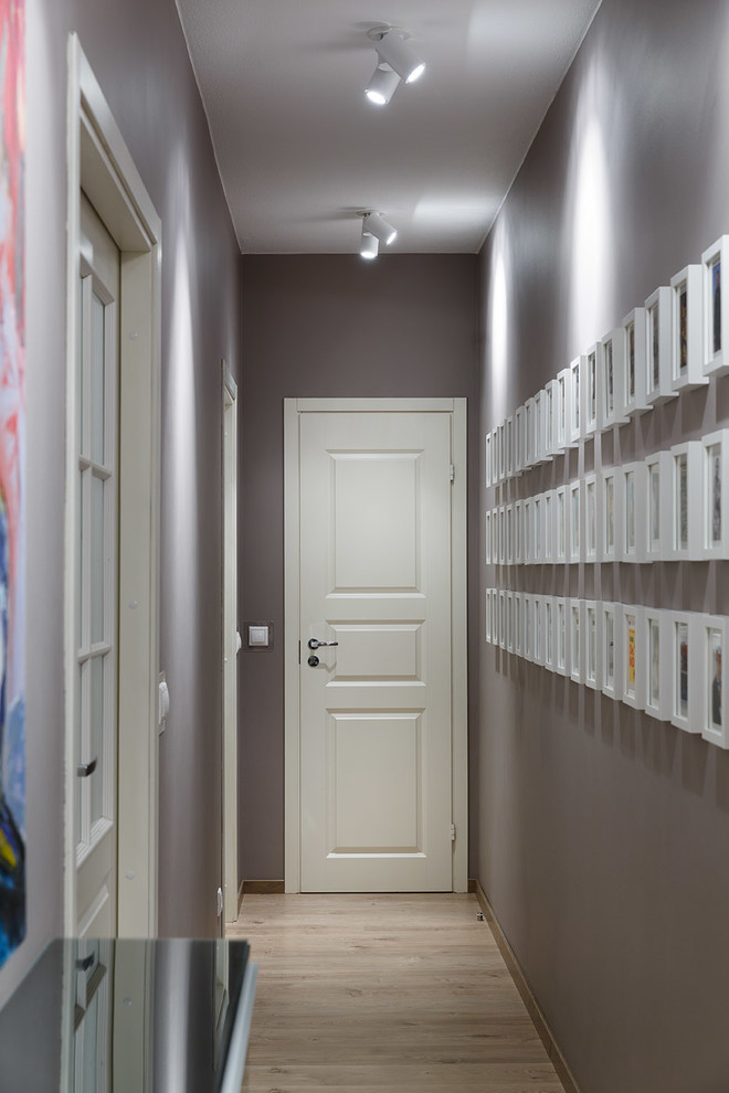 Immagine di un ingresso o corridoio design con pareti grigie e parquet chiaro