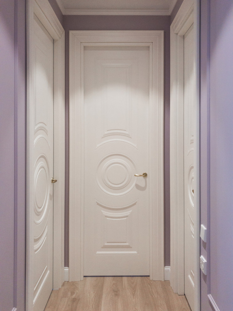 На фото: коридор среднего размера в стиле неоклассика (современная классика) с фиолетовыми стенами, полом из ламината и бежевым полом с