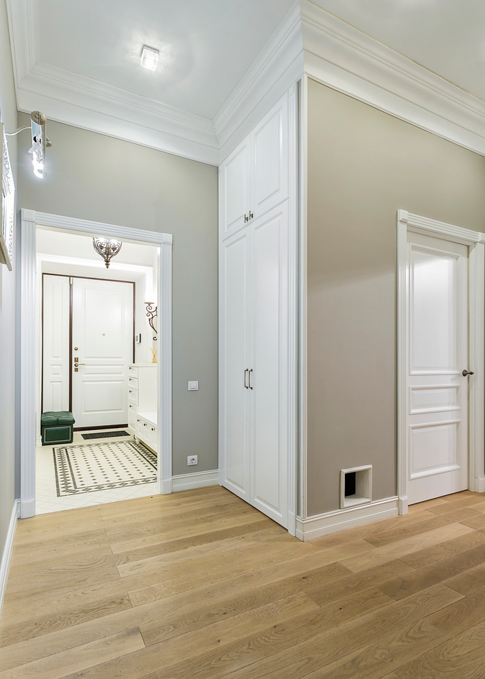 Foto de recibidores y pasillos clásicos con paredes grises y suelo de madera clara
