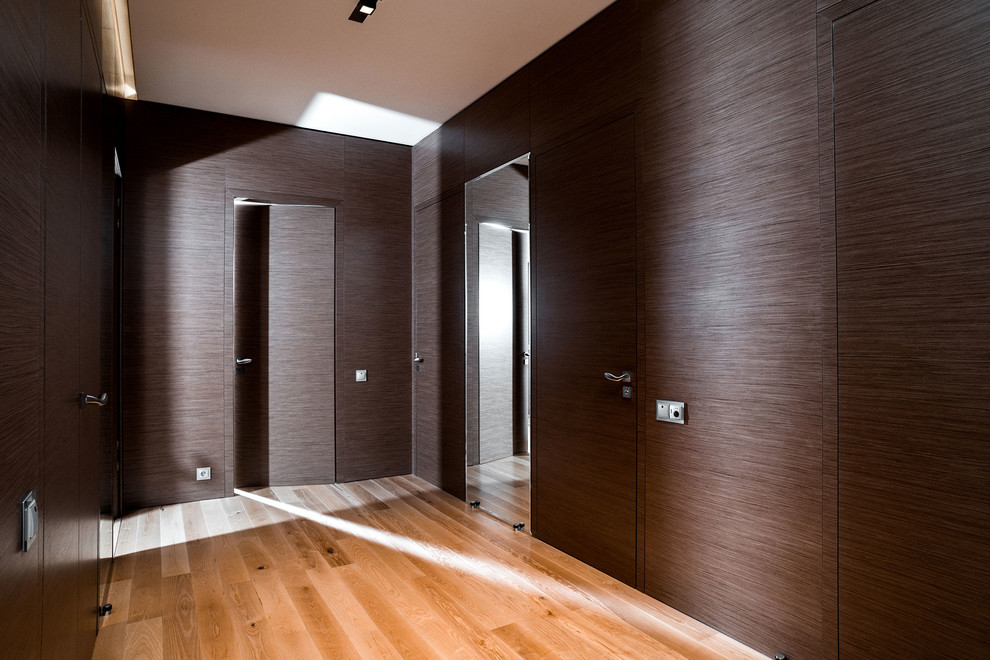 Foto di un ingresso o corridoio design con pareti marroni, pavimento in legno massello medio e pavimento marrone