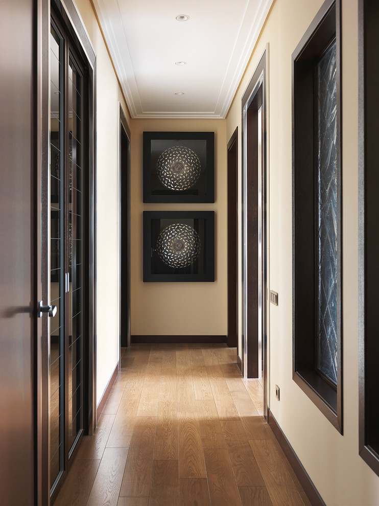 Modelo de recibidores y pasillos contemporáneos con paredes beige, suelo de madera en tonos medios y suelo marrón