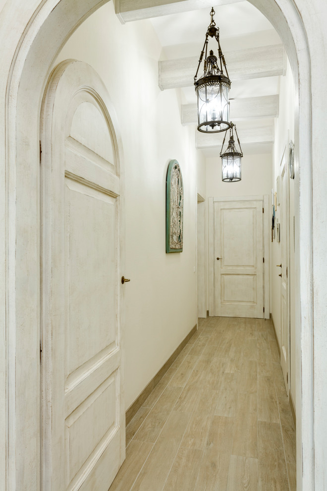 Inspiration for a mid-sized farmhouse porcelain tile and beige floor hallway remodel in Saint Petersburg with white walls