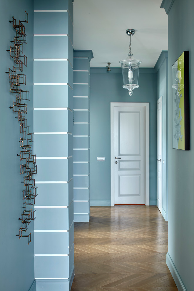 Esempio di un ingresso o corridoio contemporaneo con pareti blu e pavimento in legno massello medio