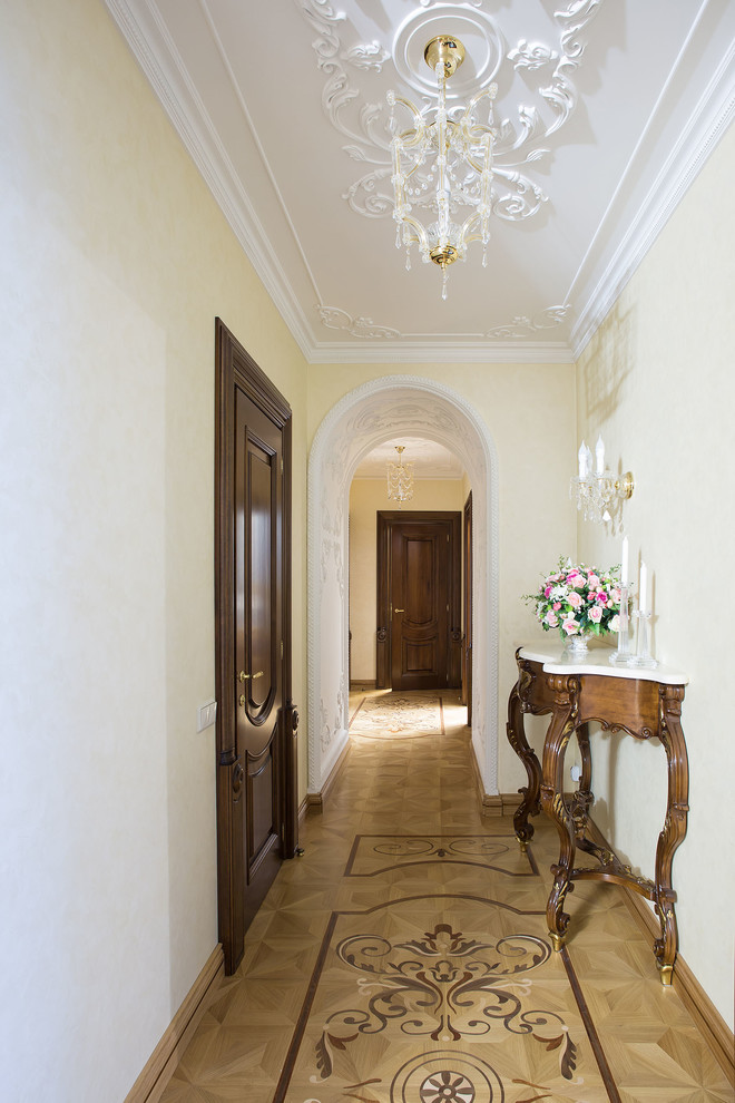 Diseño de recibidores y pasillos clásicos con paredes blancas y suelo de madera clara
