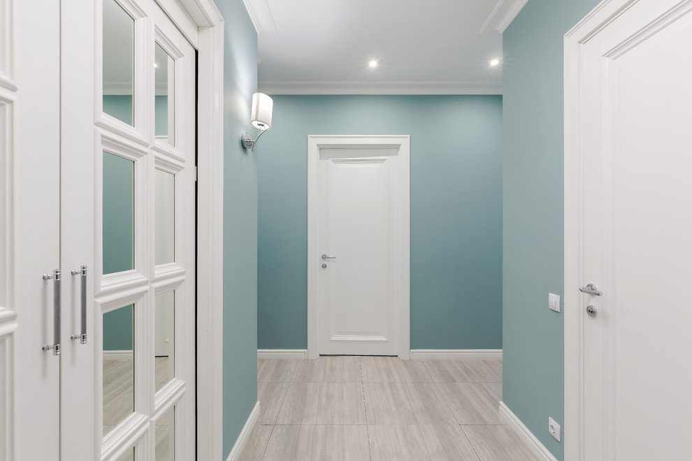 Immagine di un piccolo ingresso o corridoio chic con pavimento in gres porcellanato, pareti blu e pavimento beige