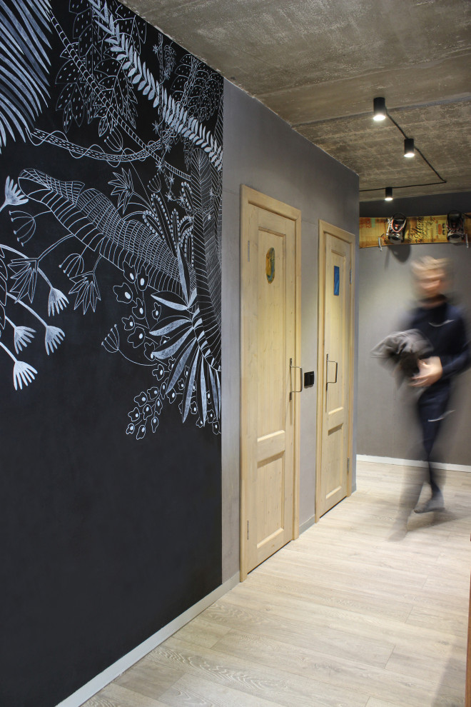 Idée de décoration pour un petit couloir urbain avec un mur gris, sol en stratifié et un sol gris.