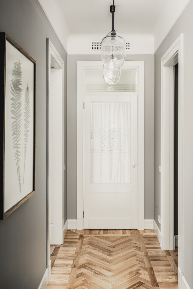 Esempio di un ingresso o corridoio classico con pareti grigie, pavimento in legno massello medio e pavimento marrone