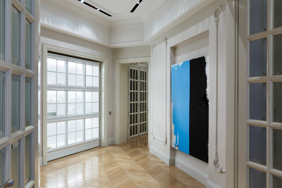 Ispirazione per un ingresso o corridoio contemporaneo con pareti bianche e parquet chiaro