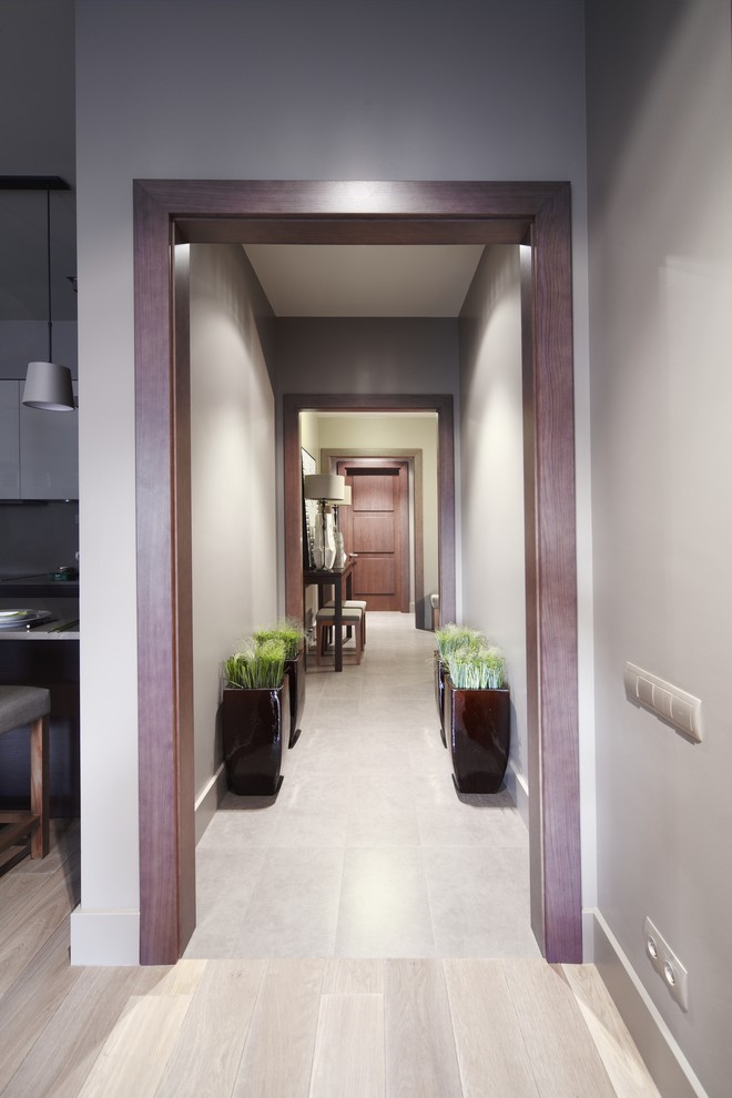 Exemple d'un grand couloir tendance avec un mur beige et un sol en bois brun.