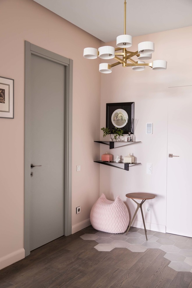 Idée de décoration pour un couloir design avec un mur rose, parquet foncé et un sol marron.