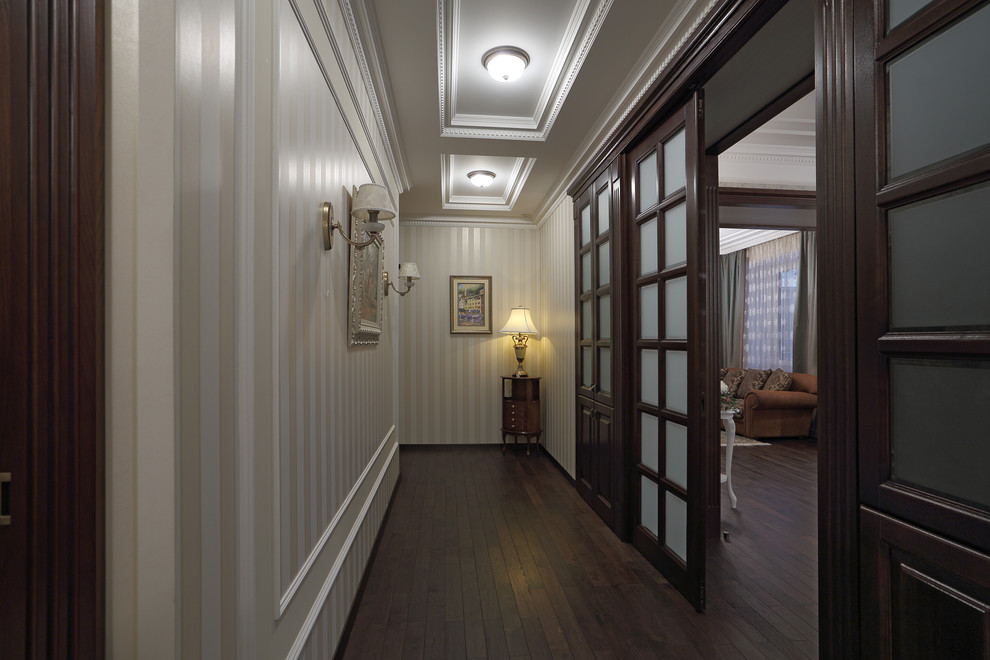 Ejemplo de recibidores y pasillos clásicos de tamaño medio con paredes beige y suelo de madera oscura