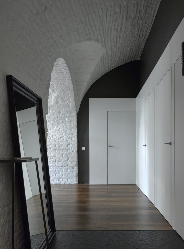 На фото: коридор в современном стиле с черными стенами, темным паркетным полом и коричневым полом с
