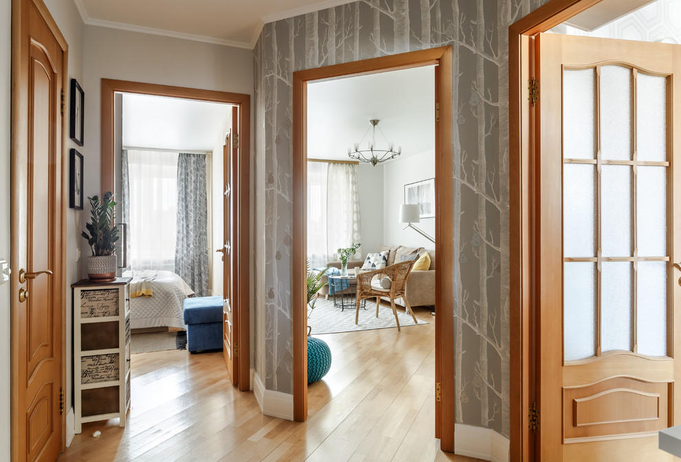 На фото: коридор: освещение в скандинавском стиле с серыми стенами, светлым паркетным полом и коричневым полом с