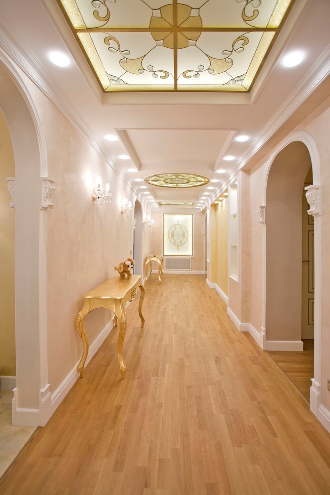 Esempio di un ingresso o corridoio tradizionale di medie dimensioni con pareti beige e pavimento in legno massello medio