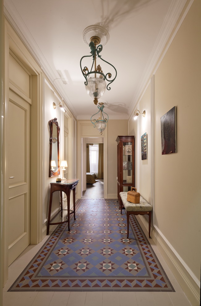 На фото: коридор в классическом стиле с бежевыми стенами, полом из керамической плитки и разноцветным полом