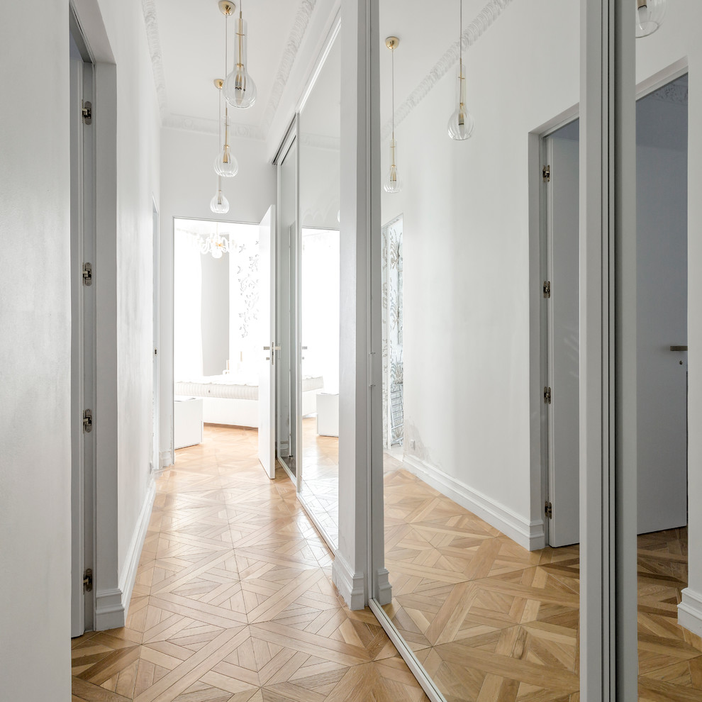 Moderner Flur mit weißer Wandfarbe und braunem Holzboden in Moskau