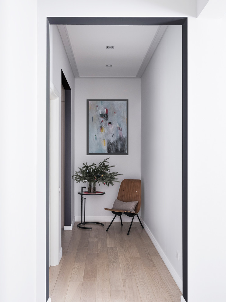 Idee per un ingresso o corridoio contemporaneo con pareti bianche, parquet chiaro e pavimento beige