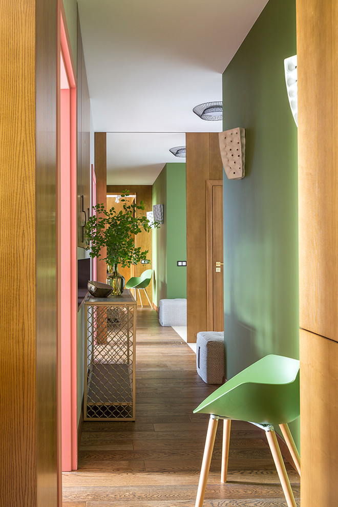 Ispirazione per un ingresso o corridoio bohémian con pareti verdi, pavimento in legno massello medio e pavimento marrone